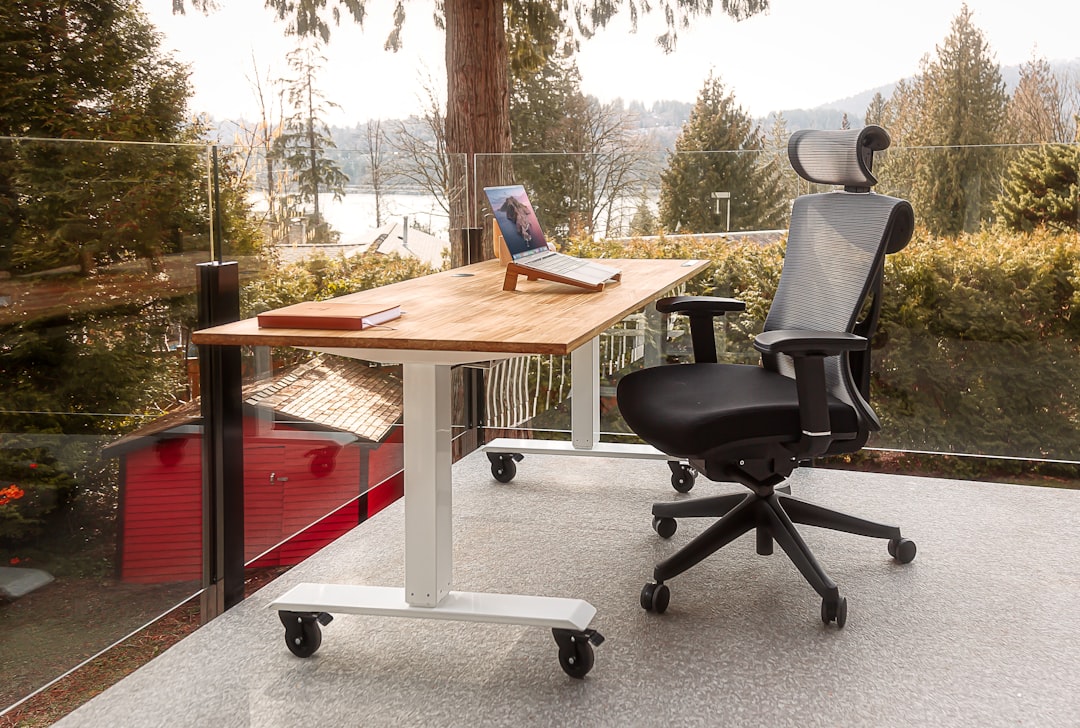 Modern ergonomic office chair positioned at a corner L-shaped desk showing clear floor space for swiveling