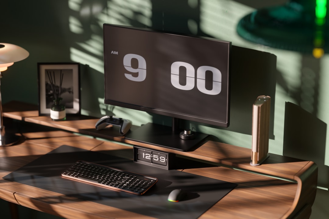 A minimalist corner desk setup featuring a monitor arm mounted to the rear edge, elevating screens off the desktop.
