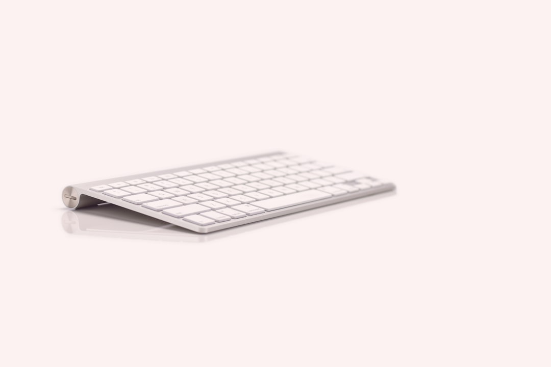 A portable ergonomic laptop setup on a table featuring a folding laptop stand and compact keyboard