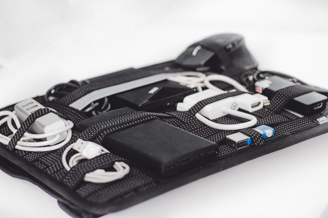 An open padded tech pouch organizer displaying neatly packed cables, power adapters, and accessories