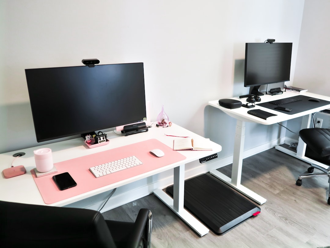 Modern aesthetic home office with an electric standing desk, walking treadmill pad, and cable management