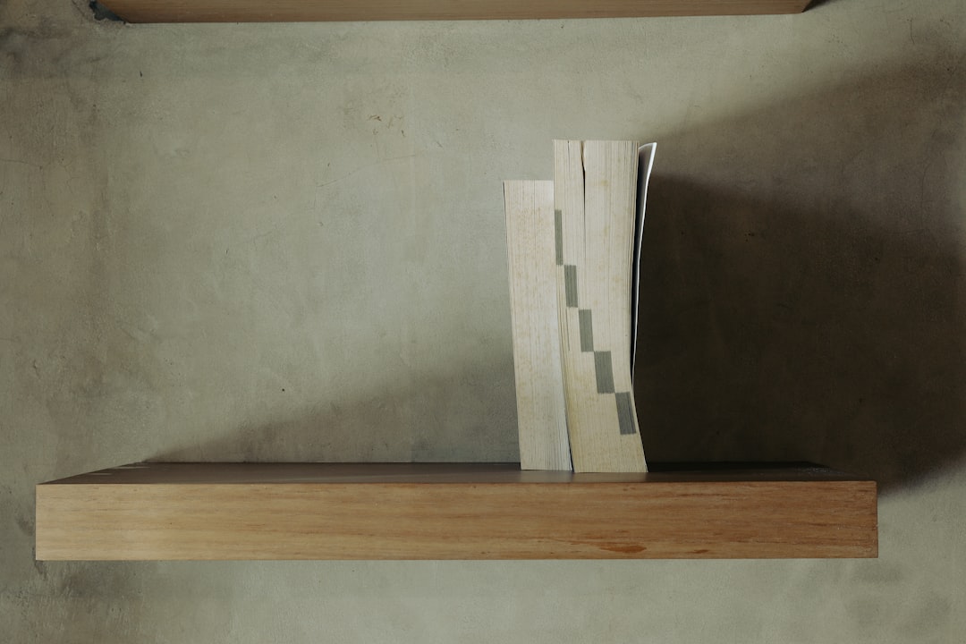 Floating wooden desk shelf mounted to wall studs inside a closet workspace.