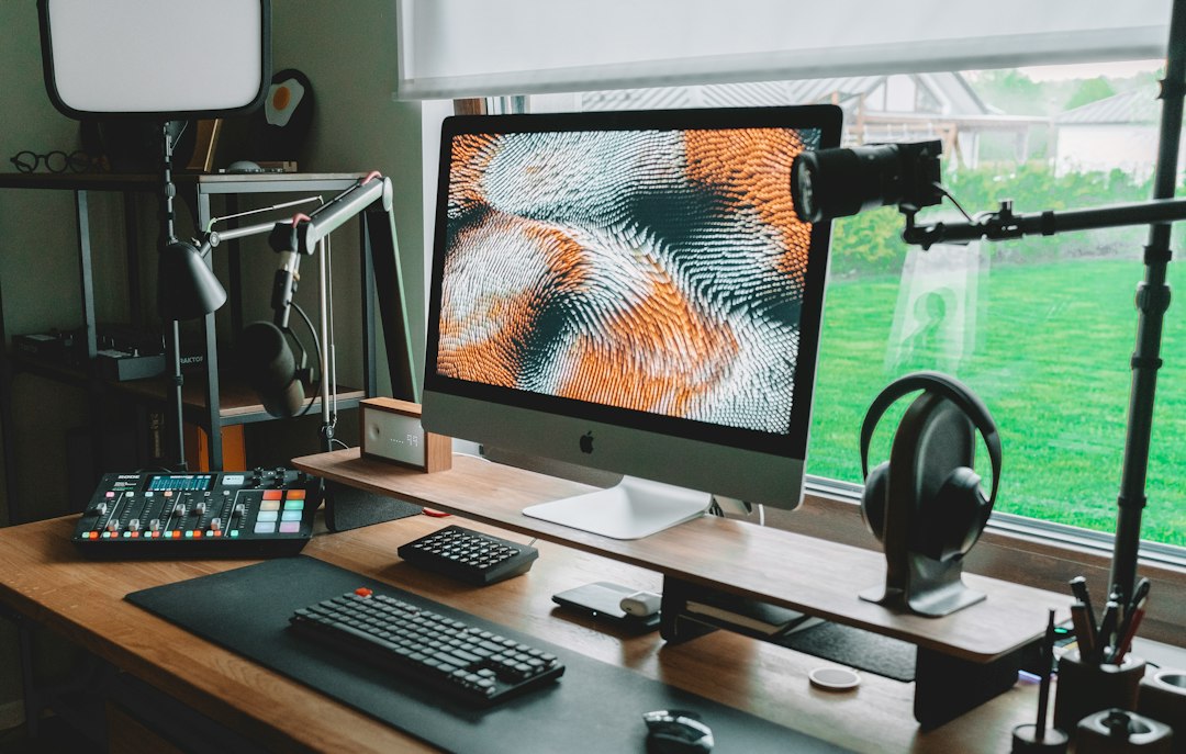 A desktop microphone mounted on a boom arm positioned close to a workspace chair in a clean home office setup.